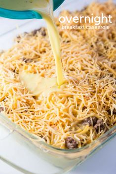 someone is pouring cheese into a casserole dish