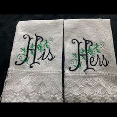 two white towels with embroidered initials on them, one has green leaves and the other has black lettering