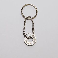 a metal keychain with the word love is written in white letters on it