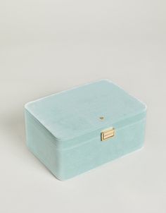 a small blue box with a gold handle on the top and bottom, sitting against a white background