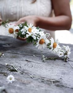 the bride is arranging daisies on her wedding day with white and yellow flowers in their hands