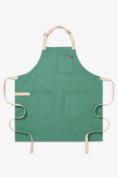 a green apron with white straps and two pockets on the front, one pocket is open