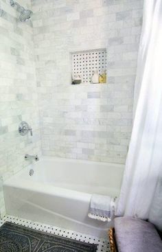 a white bath tub sitting next to a shower