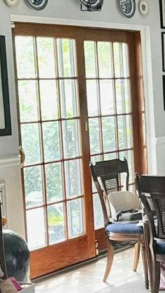 a dining room table with chairs and pictures on the wall above it's glass doors