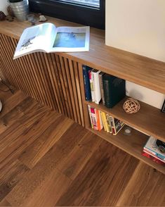 a book shelf with books on it next to a window