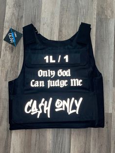 the back of a black vest with white writing on it that says, 11 / 1 only god can judge me cash only