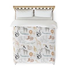 an animal themed bed spread with white sheets and pillowcases, along with two pillows