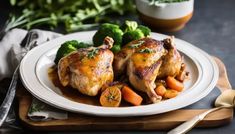 two pieces of chicken on a plate with carrots and broccoli next to it