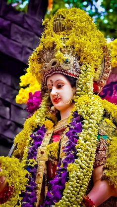 a close up of a person wearing a costume and headdress with flowers on it