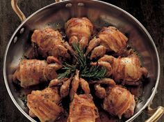 a pan filled with cooked chicken and garnished with rosemary sprigs on the side