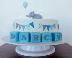 a cake with blocks spelling out the word dairy on it and an elephant in the background