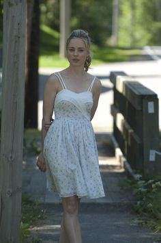 a woman in a dress is walking down the street