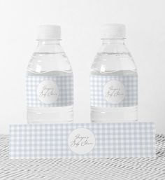 two water bottles with labels on them sitting next to each other