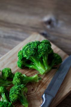 the broccoli is cut up and ready to be eaten on the cutting board