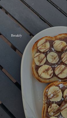 two pieces of toast topped with bananas and chocolate