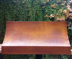 a metal bench sitting in front of a green wall