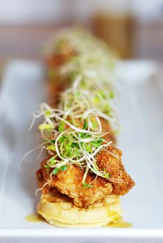 a white plate topped with food and garnished with sprouts on top