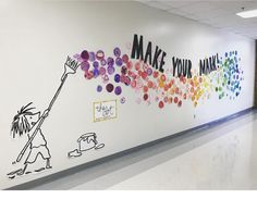 an office hallway painted with colorful balloons and the words make your mind work on it