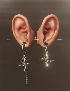 two ear piercings with chains attached to them, one has a star on it