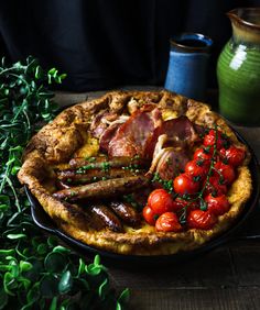 a pie with meat, tomatoes and other food items