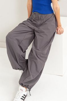 Get ready for some cute strutin' in these Street Style Parachute Pants. Featuring a high waist with a drawstring and button closure, plus roomy pockets and adjustable ankles, you'll be both comfy and stylish. Perfect for a laid-back day or a casual night out. Available in Gray and Black! 100% Nylon DZ24C114 Casual Night Out, Back Day, Utility Pants, Get Ready, Parachute Pants, Night Out, High Waist, Street Style, High Waisted