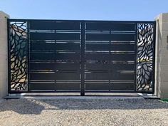 an iron gate with decorative designs on the top and bottom bars, in front of a concrete wall