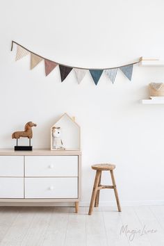 a white dresser sitting next to a wooden toy horse