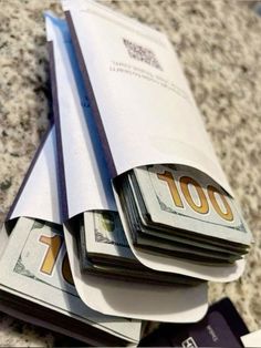 stacks of money sitting on top of each other in front of a pile of papers