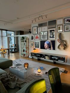 a living room filled with lots of furniture and pictures on the wall next to a flat screen tv