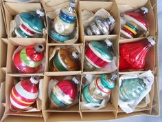 a box filled with lots of different colored christmas ornament ornaments on top of a table