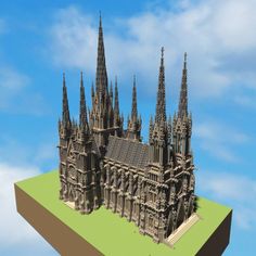 a model of a cathedral on top of a green surface with blue sky in the background