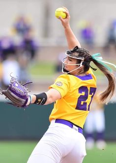 a softball player throwing a ball on top of a field