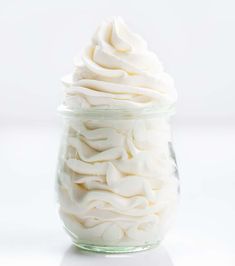 a glass jar filled with whipped cream on top of a table