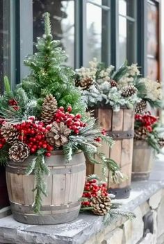 christmas decorations in wooden buckets on a window sill with pine cones and berries