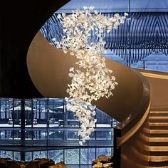 a large chandelier hanging from the side of a spiral staircase in a building