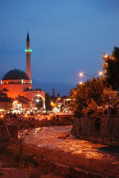 a mosque lit up at night in the middle of a river with lights on it