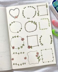 an open notebook with doodles and flowers on the pages, next to markers and pens