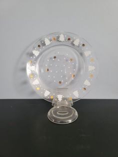 a clear glass plate with gold dots on it