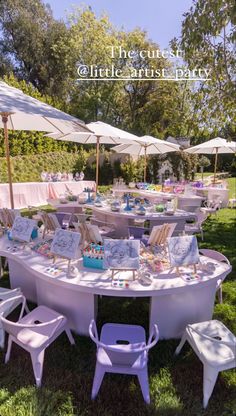 an outdoor table set up with white chairs and tables covered by umbrellas for a baby shower