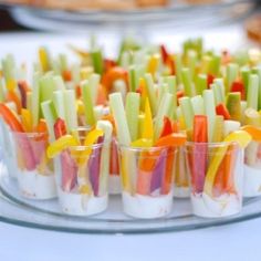 many small cups filled with food on top of a glass platter at a party