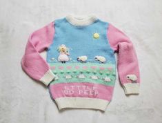 a pink and blue sweater with sheep on it