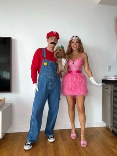 a man and woman dressed in costumes standing next to each other on a hard wood floor