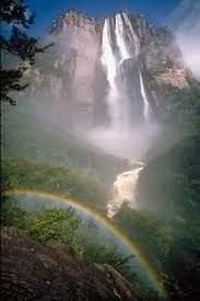 a waterfall with a rainbow in the foreground