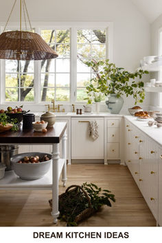 a kitchen filled with lots of white cabinets and counter top space next to a window