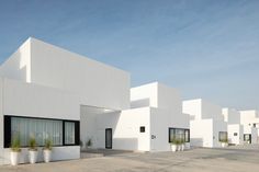 a white building with many windows and plants