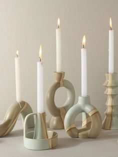 several candles are lined up in different shapes and sizes, with one candle lit next to the other