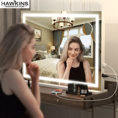 a woman is looking at herself in the mirror