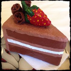 a piece of cake with chocolate frosting and strawberries sitting on top of it