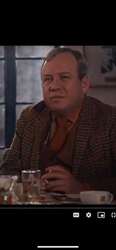 a man sitting at a table with glasses in front of him