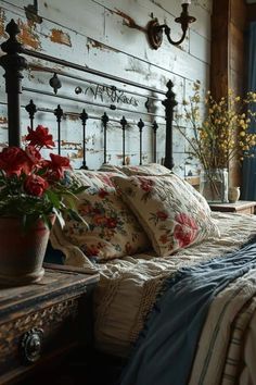 a bed with pillows and flowers on top of it next to a wooden headboard